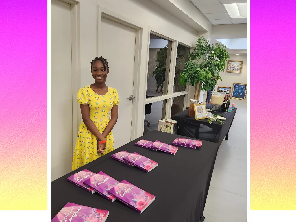 Abigail Samson standing beside a table of Candytopia books at a signing event