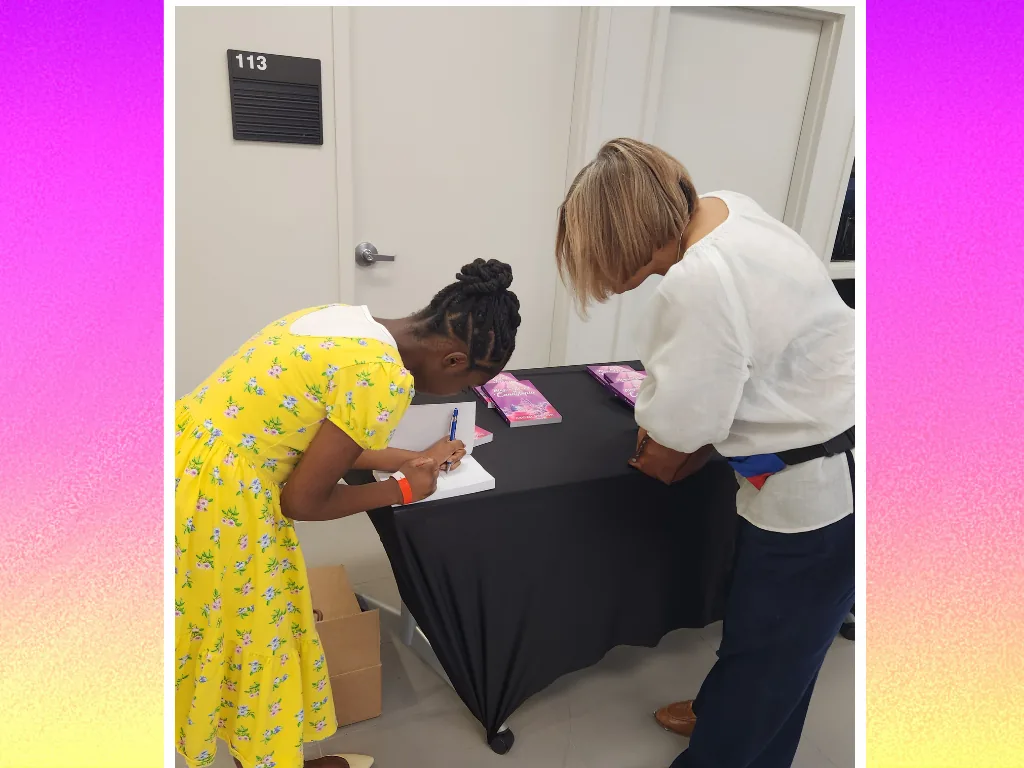 A young reader writing at the Candytopia book-signing table